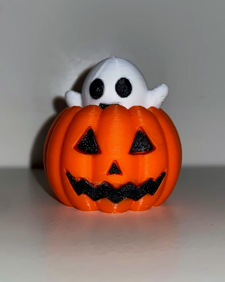 Brinquedo de Halloween: abóbora laranja sorridente com um fantasminha branco saindo de dentro
